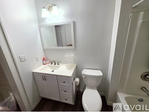 A white toilet sits next to a sink in a small bathroom.