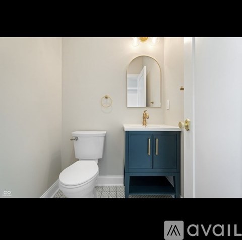 A white toilet sits next to a cabinet with a mirror above it.