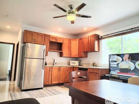 A kitchen with wooden cabinets and a stainless steel refrigerator.