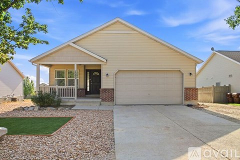 A house with a garage and a driveway in front.