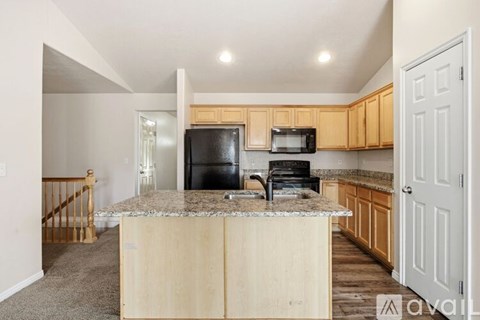A kitchen with wooden cabinets and a granite countertop.