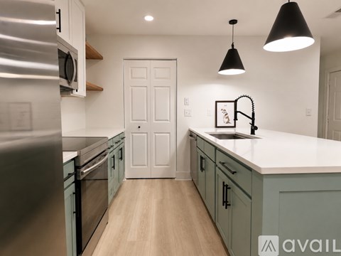 A kitchen with a white door in the middle of the room.