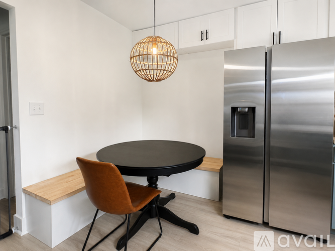 A kitchen with a round table and a bench seat.