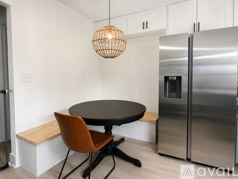A kitchen with a round table and a bench seat.