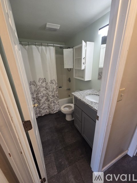 A bathroom with a toilet, sink, and shower.