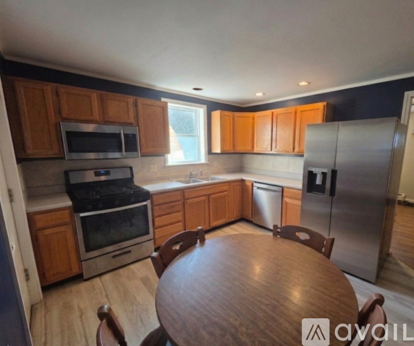 A kitchen with wooden cabinets and stainless steel appliances.