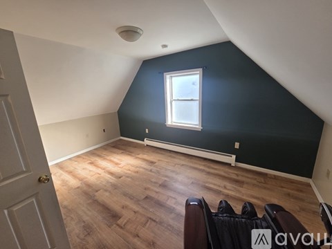 A room with a window and a wooden floor.