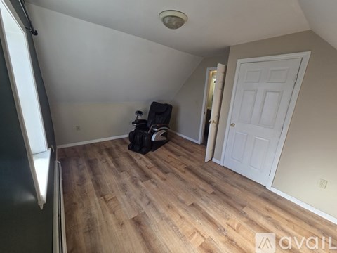 A room with a white door and a wooden floor.