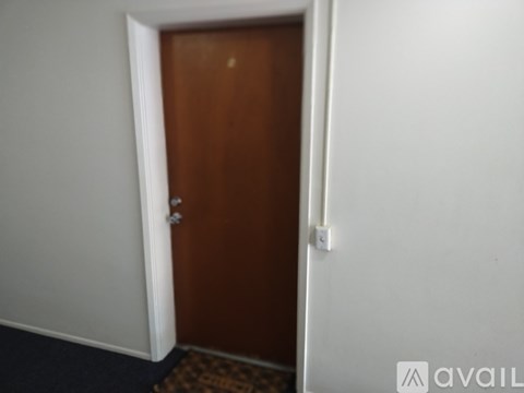 A brown door is in a white room.