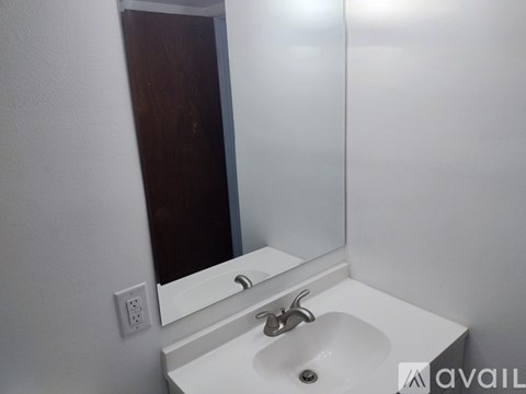 A white sink in a bathroom with a mirror above it.