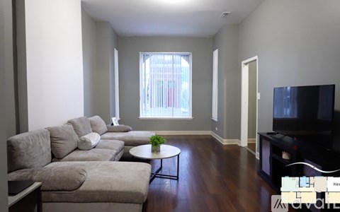 A living room with a grey couch and a small table in front of it.