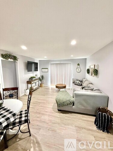 A living room with a couch, chair, and television.