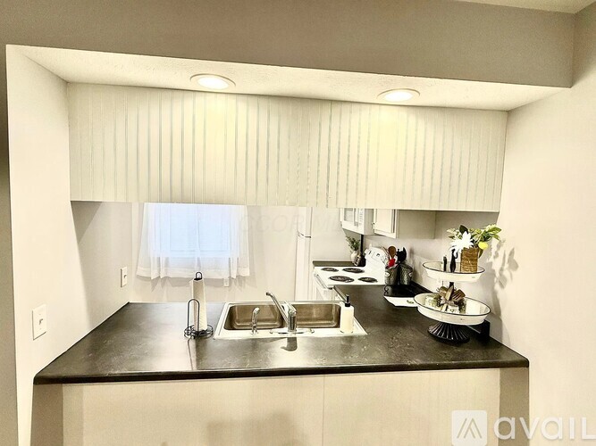 A kitchen with a sink and a window with blinds.