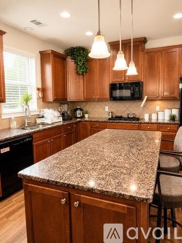A kitchen with granite countertops and wooden cabinets.
