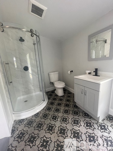 A white bathroom with a black and white floor.