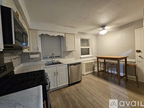 A kitchen with a stove top oven, microwave, and a dining table with chairs.