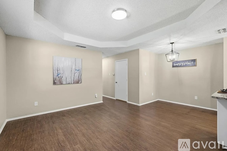 A room with wood flooring and a painting on the wall.