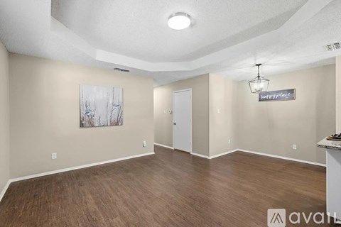 A room with wood flooring and a painting on the wall.