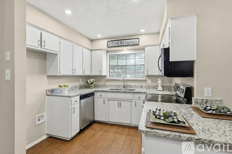 A kitchen with a granite countertop and white cabinets.