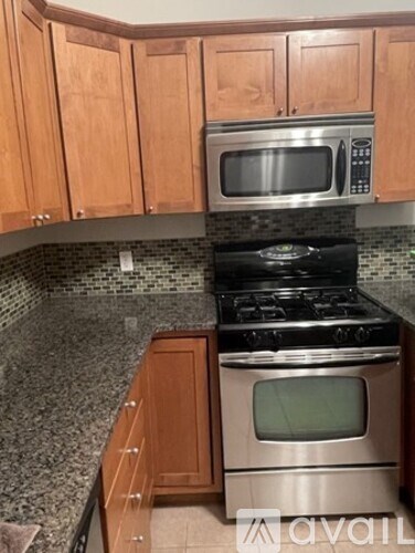 A kitchen with a stove and microwave above it.