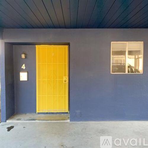 A yellow door with a number 4 on the wall above it.