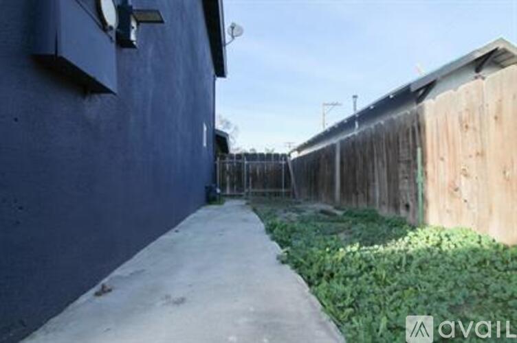 A narrow concrete pathway leads between two buildings.