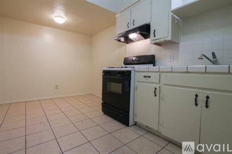 A kitchen with white cabinets and a black oven.