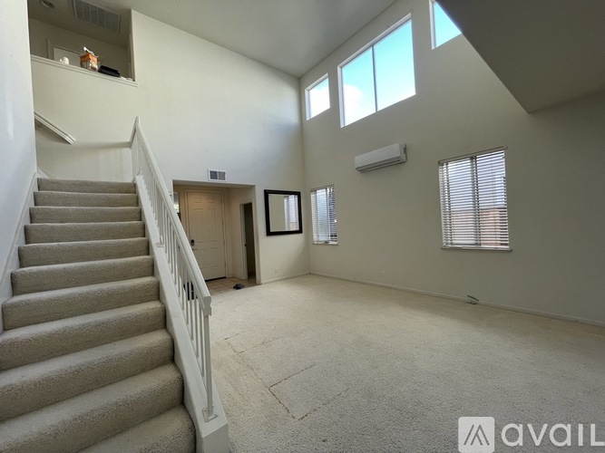 A spacious room with a staircase leading to the upper floor.