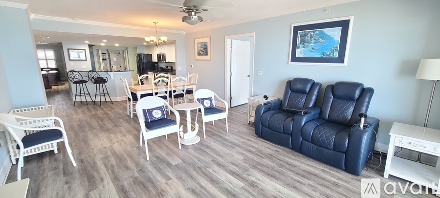 A living room with a blue sofa and white chairs.