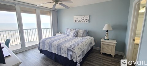 A bedroom with a large bed and a view of the ocean.