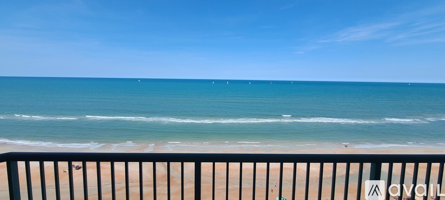 A beach scene with a clear blue sky and calm sea.