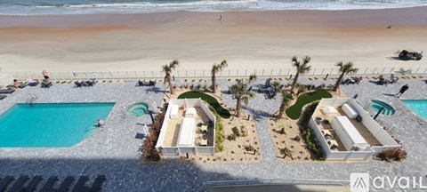 A beachfront property with a swimming pool and palm trees.
