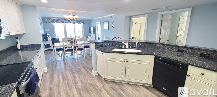 A kitchen with a black countertop and a white sink.