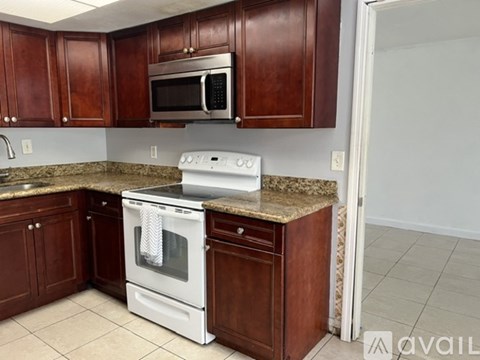 A kitchen with brown cabinets and a white oven.