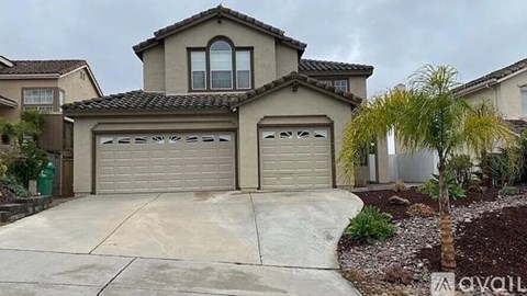 A house with a grey roof and two garages.