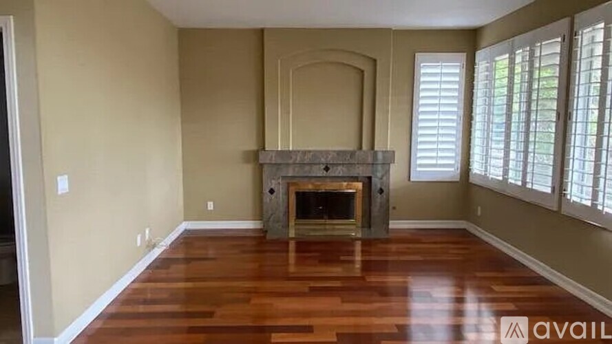 A living room with a fireplace and wood flooring.