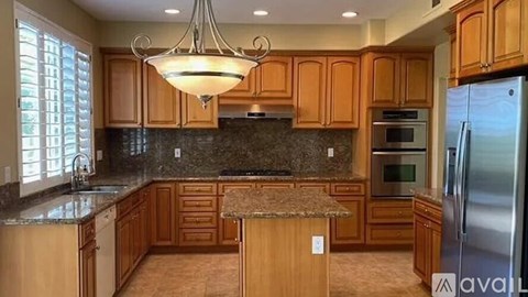 A kitchen with wooden cabinets and a granite countertop.