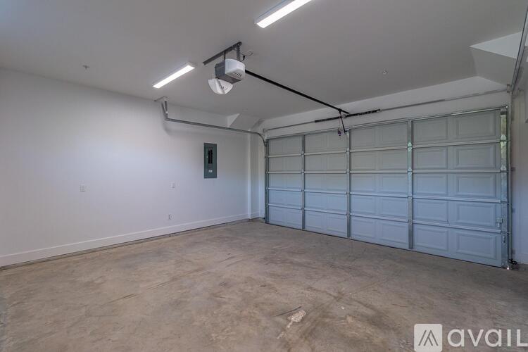 A spacious garage with a closed white door and a light on the ceiling.