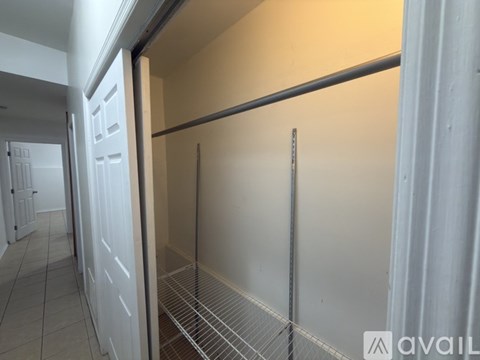 A white door is open to a room with a metal shelf.