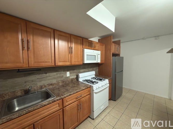 A kitchen with wooden cabinets and a white stove top oven.