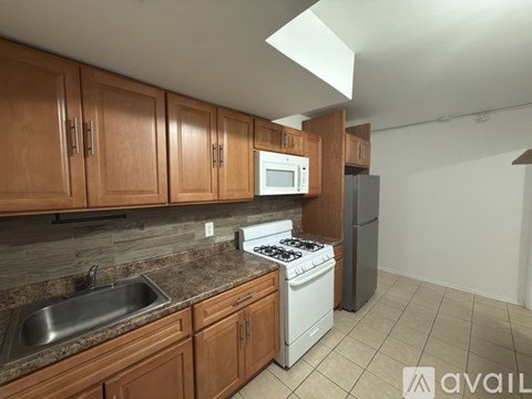 A kitchen with wooden cabinets and a white stove top oven.