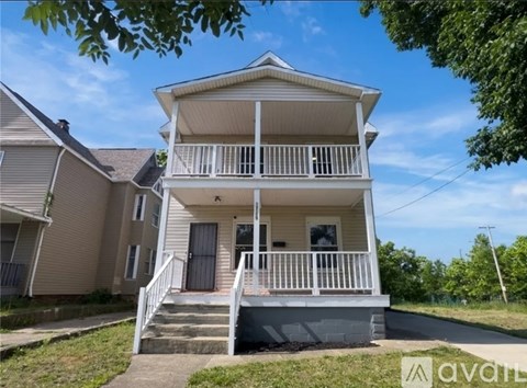A two-story house with a balcony and a front porch.