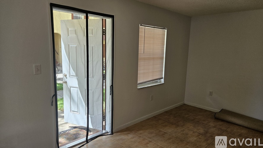 A room with a sliding glass door leading to a backyard.