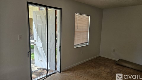 A room with a sliding glass door leading to a backyard.