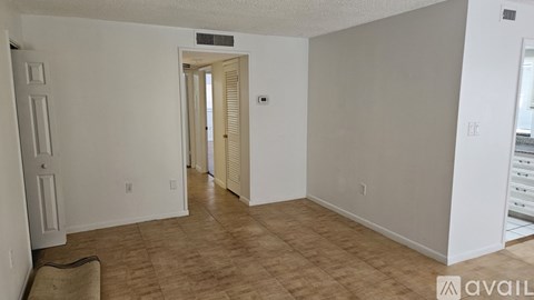 A room with a door and a window with blinds.