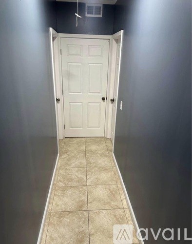 A white door is in the middle of a hallway.