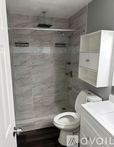 A bathroom with a toilet, sink, and walk-in shower.