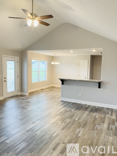 A spacious room with a ceiling fan and lighting fixtures.