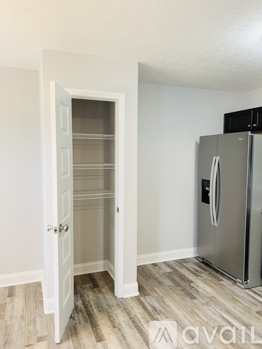 A kitchen with a white door and a stainless steel refrigerator.