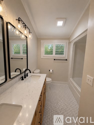 A bathroom with a marble countertop and a large mirror.